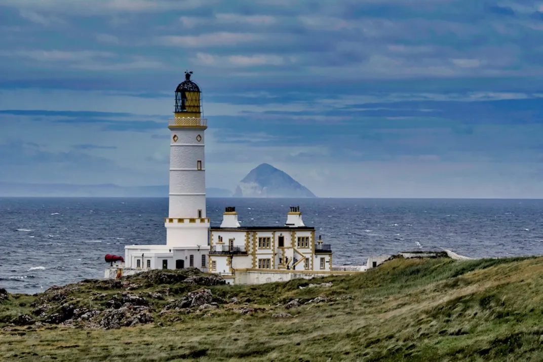 White building with a tall white tower in front of the sea