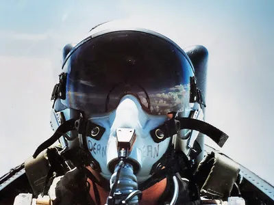 Selfie of Joy Dean in her flight helmet. Clouds are reflected in the visor.