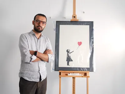 Lindor Mehmetaj, the manager of&nbsp;London&#39;s Grove Gallery,&nbsp;with Banksy&#39;s Girl With Balloon