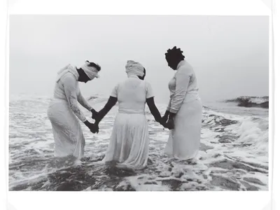 people holding hands while standing in ocean water