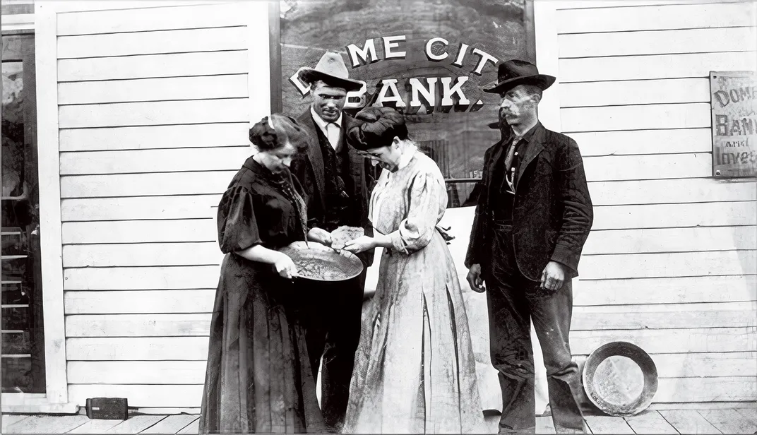 two men and two women inspect a gold nugget