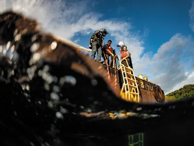 A diver prepares to enter the water of Malakal Harbor in Palau, where the plane flown by U.S. Navy pilot Jay Ross Manown Jr. was shot down in September 1944.