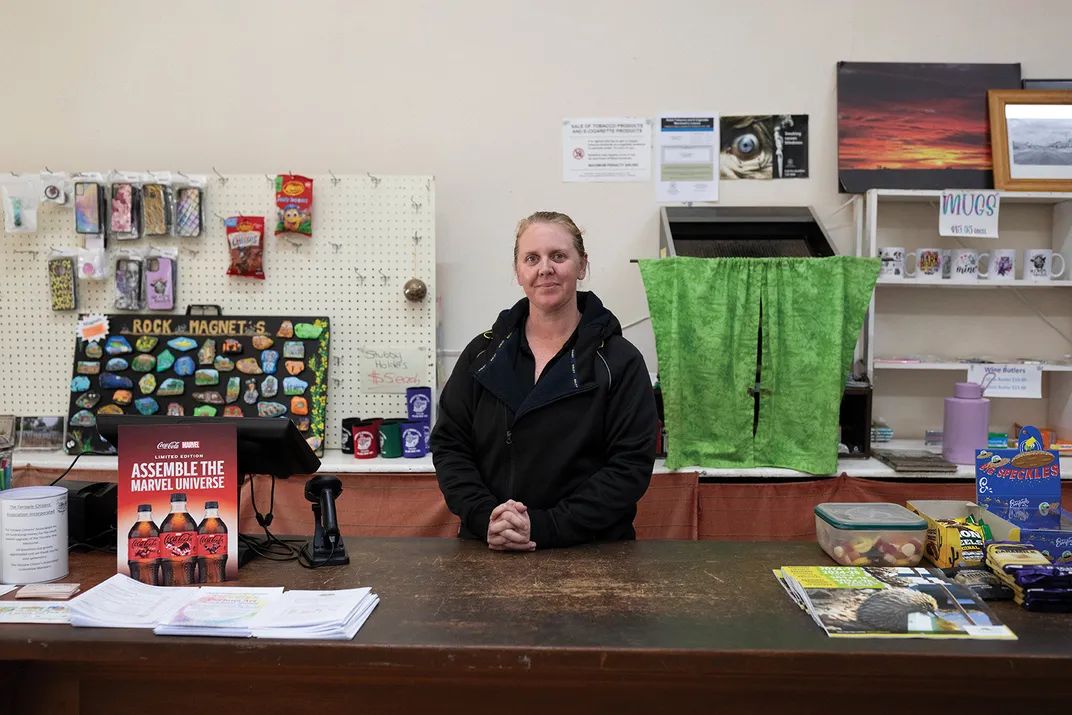 a store clerk stands for portrait at a counter