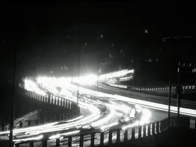 Ribbons of light slash through the darkness that is New York City during the Giant power Failure November (th. The "ribbons" are formed by the lights of vehicles moving along a highway.